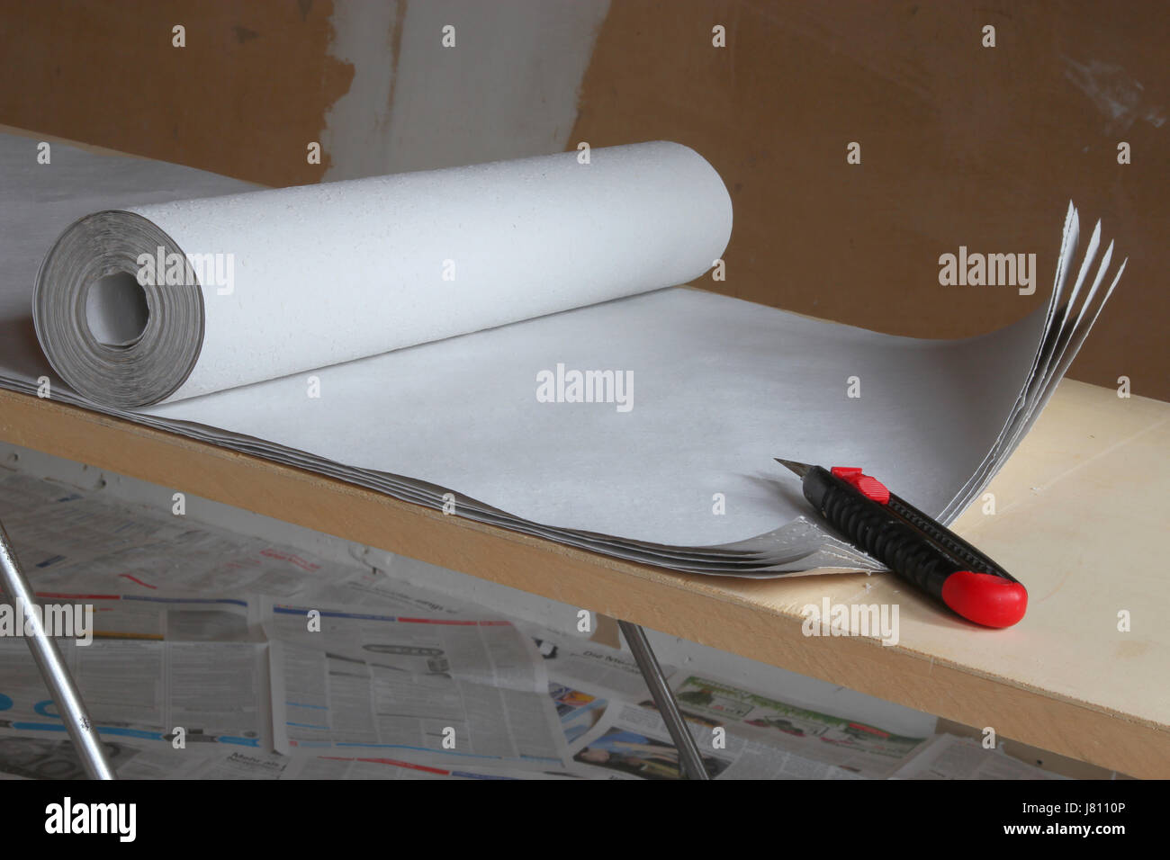 L'applicazione su carta da parati ruvida sulla incollando la tabella Foto Stock