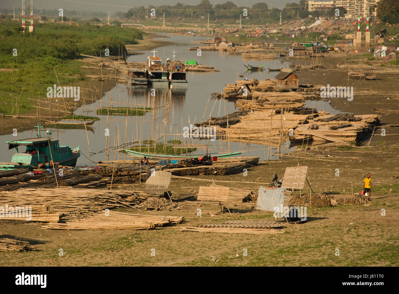 ASIA, Myanmar (Birmania), Mandalay fiume Irrawaddy, legno accumulato dal bordo d'acqua per il trasporto fluviale Foto Stock