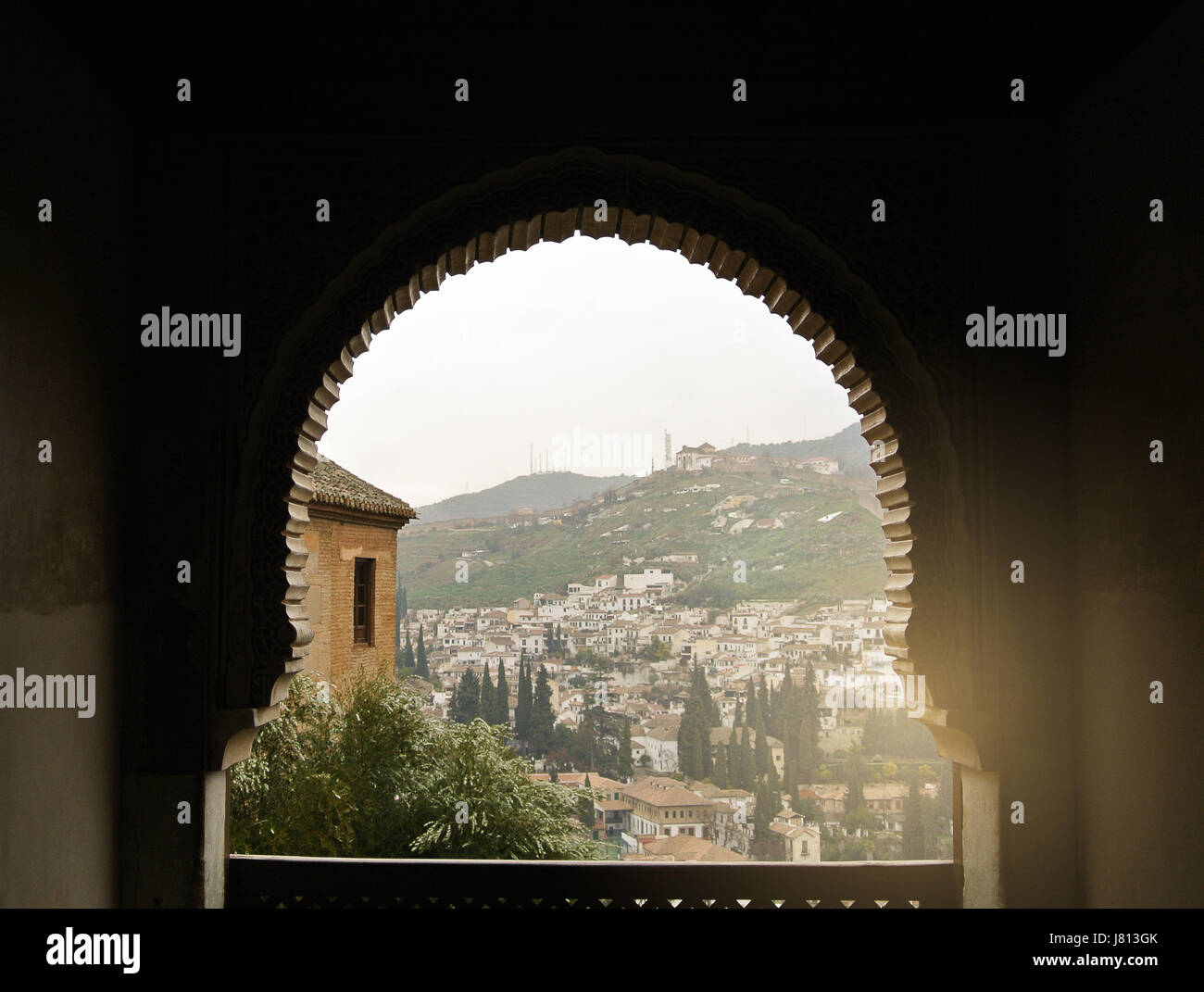 GRANADA, Spagna - 10 febbraio 2015: una vista a vecchie case bianche di Granada sulla collina attraverso una finestra decorata con ornamenti orientali, palazzo di Foto Stock