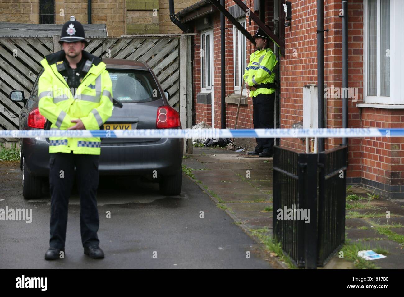 Un poliziotto sta al di fuori di una casa in Brideoak Street a Cheetham Hill, Manchester, che venne razziato dopo l attacco terroristico nella città in precedenza questa settimana. Foto Stock