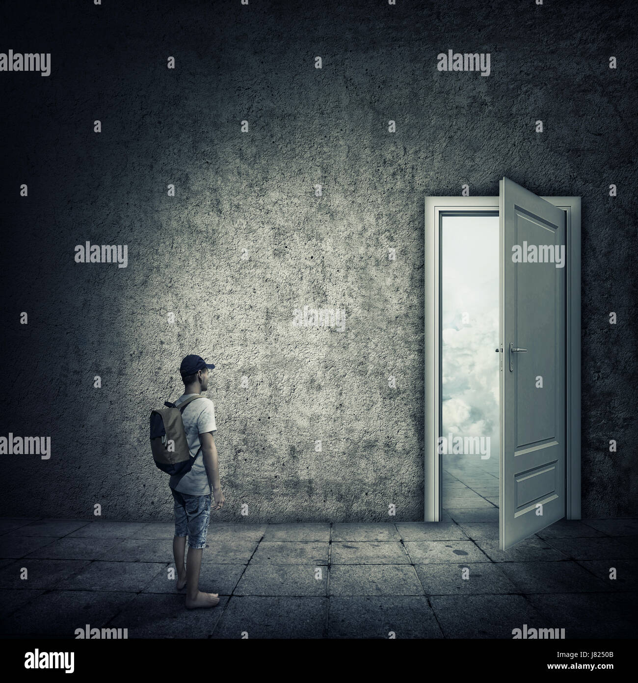Idea astratta di una persona in piedi in una stanza buia, davanti a una porta aperta. Opportunità di fuga, entrata in un altro mondo. Foto Stock