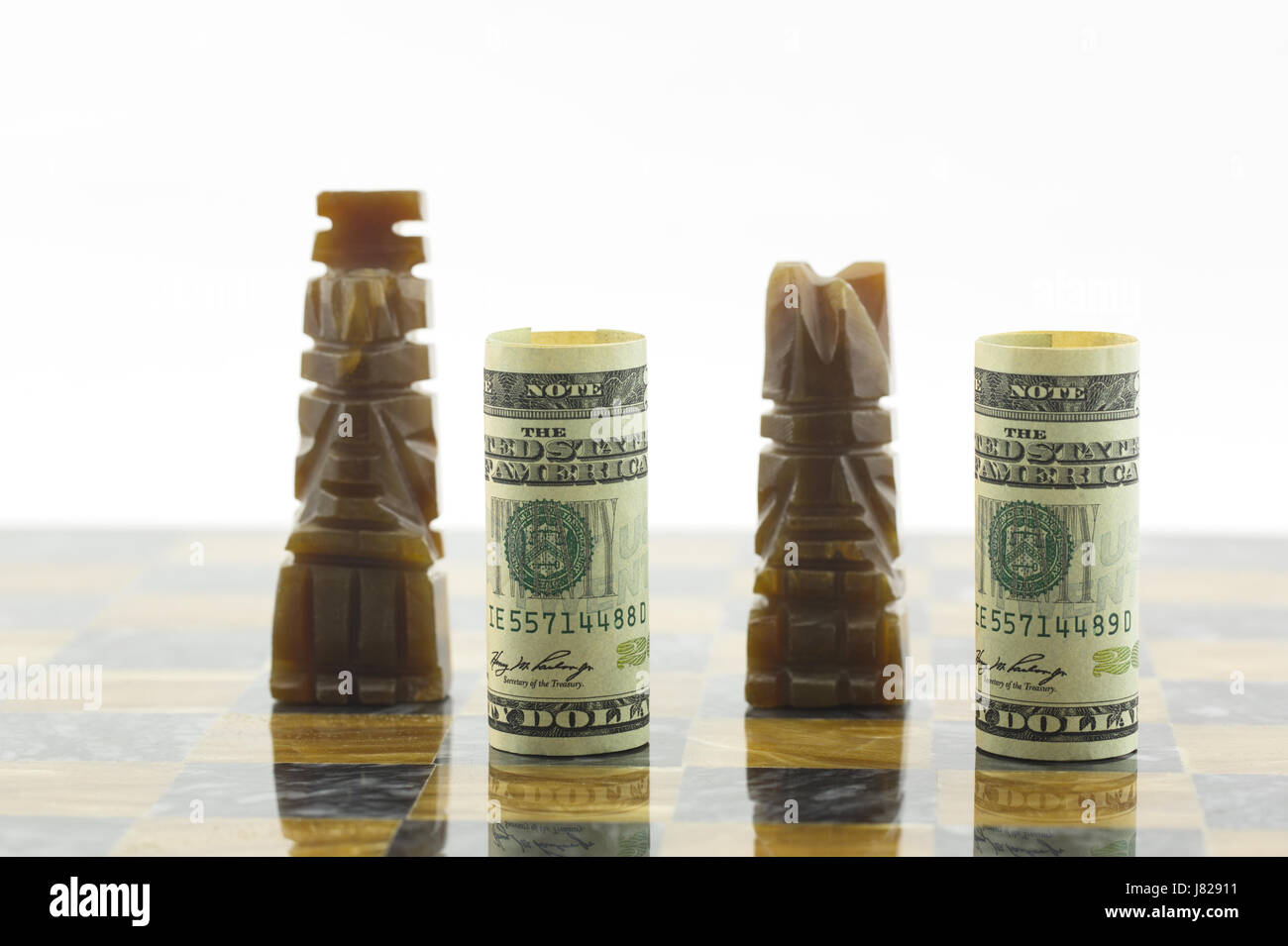 Moneta americana posta con pezzi di scacchi sul nero e marrone scheda di gioco riflettono il fatto che negli Stati Uniti è di investimento nel gioco. Foto Stock