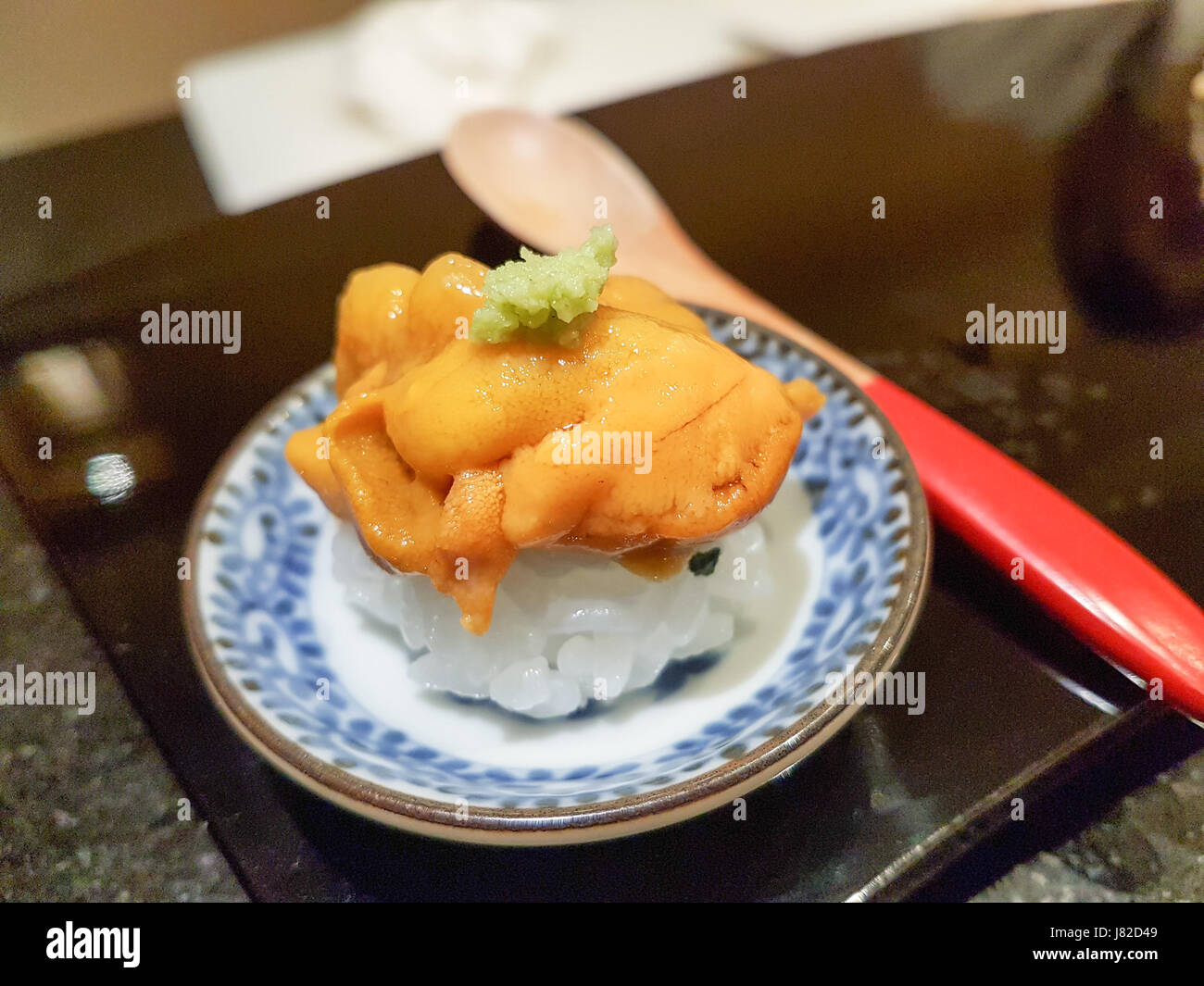 Uni o ricci di mare serviti sulla sommità del riso sushi in piccola parte Foto Stock