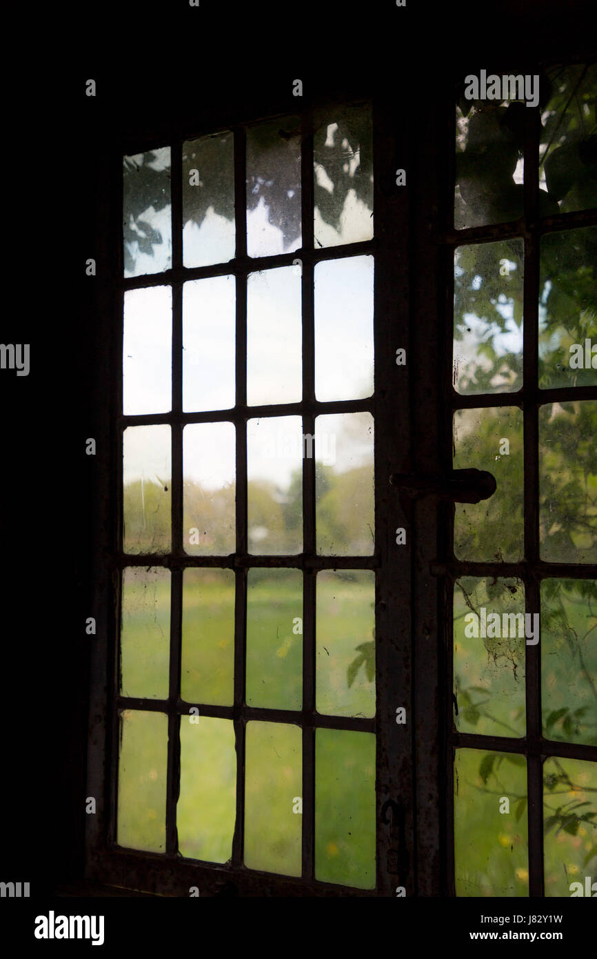 Una finestra shilouetted affacciato sulla campagna a Packwood House NT. Maggio 2017 Foto Stock