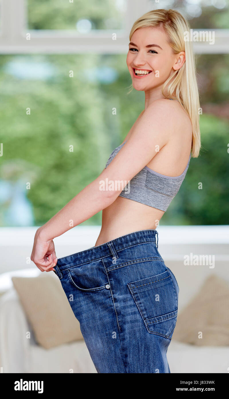 Ragazza che indossa jeans di grandi dimensioni - La perdita di peso Foto Stock