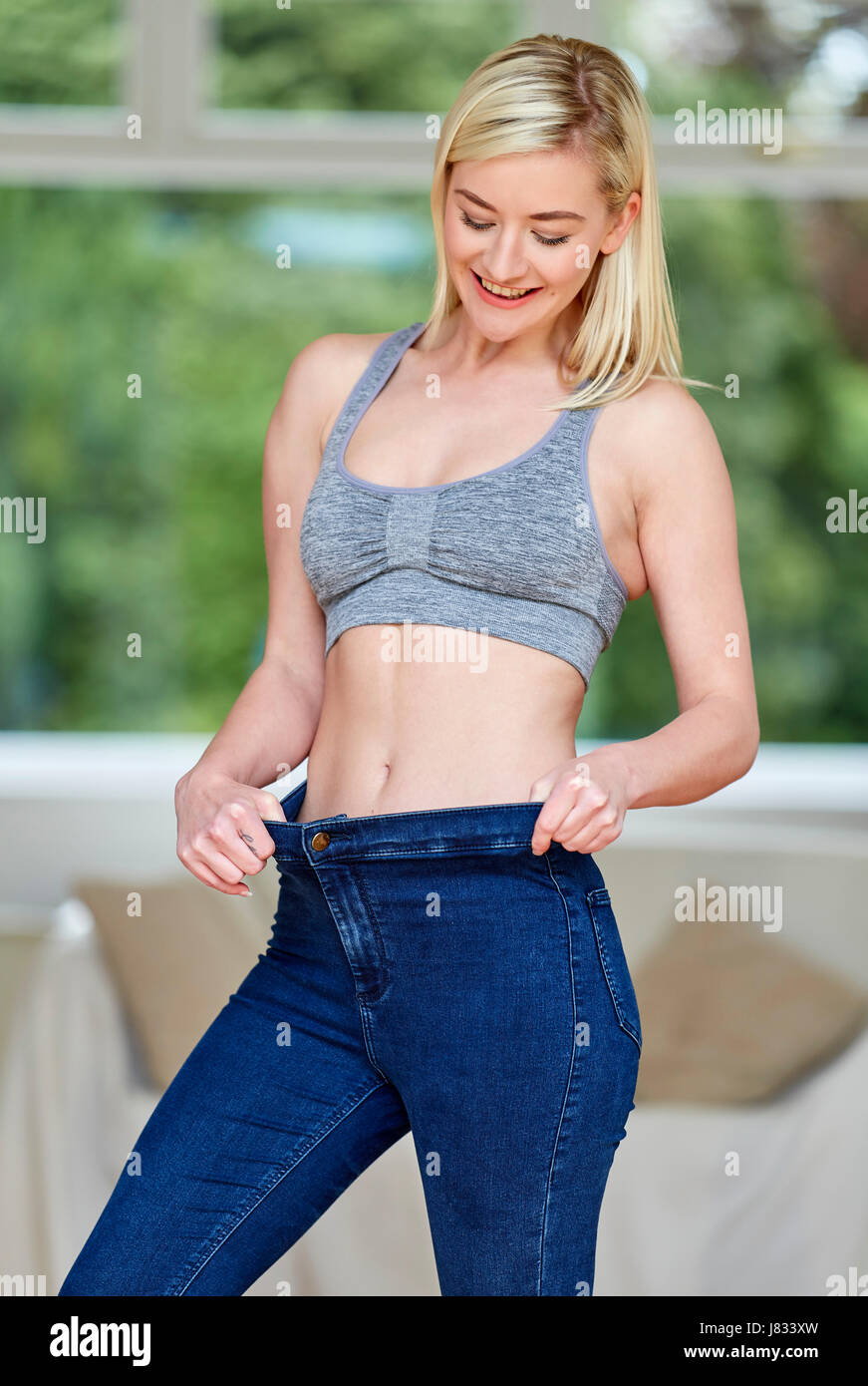 Ragazza che indossa jeans di grandi dimensioni - La perdita di peso Foto  stock - Alamy