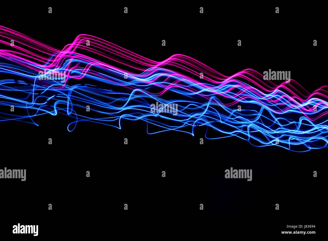 Blu e Rosa luce fotografia pittura, increspature e onde contro uno sfondo nero Foto Stock