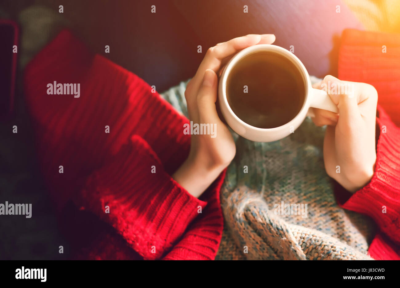 Ora del tè del mattino. Donna mani tazza di tè nella luce del sole di mattina. Foto Stock