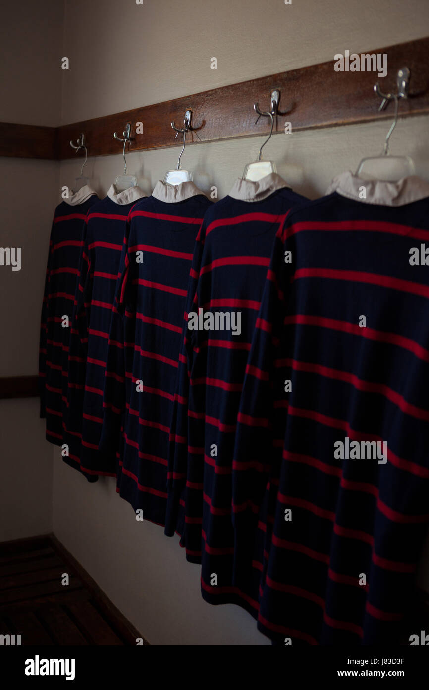 Camicie Rugby sospesi dal portabiti in camera Foto Stock