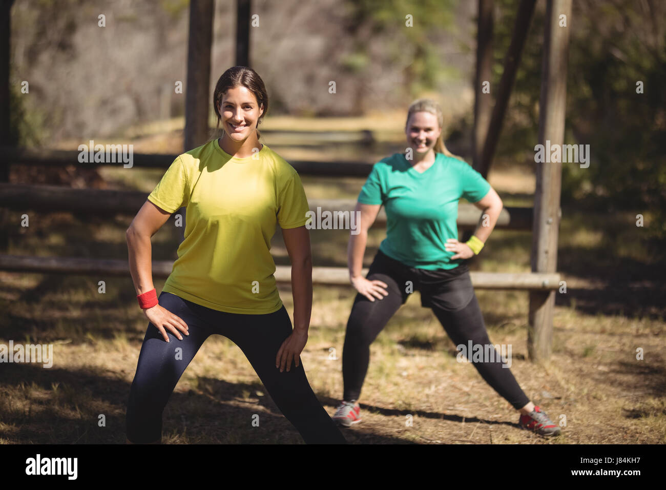 Ritratto di felice delle donne che esercitano durante la corsa a ostacoli in piedi l'usura Foto Stock