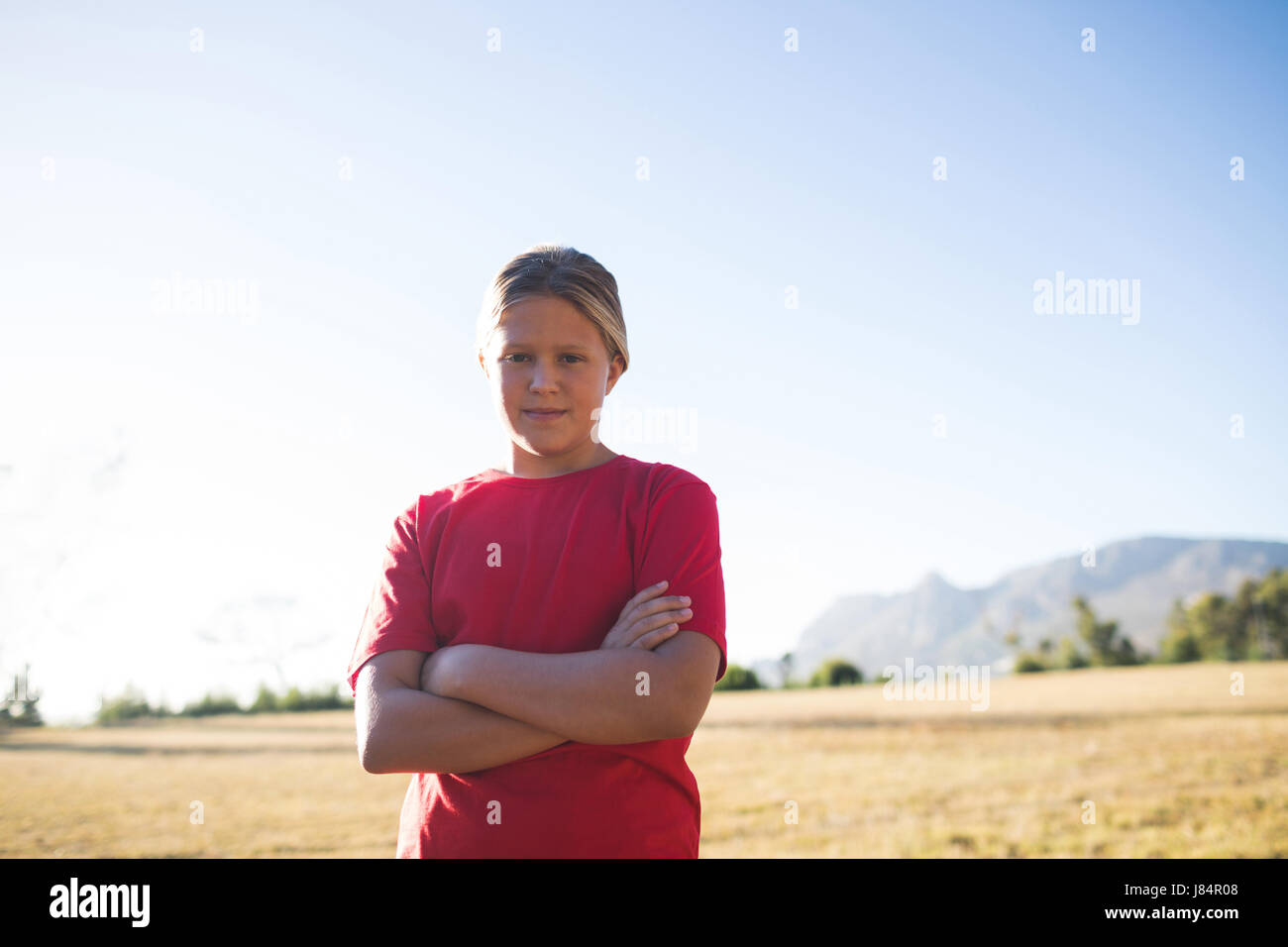 Ritratto di ragazza in piedi con le braccia incrociate in boot camp Foto Stock