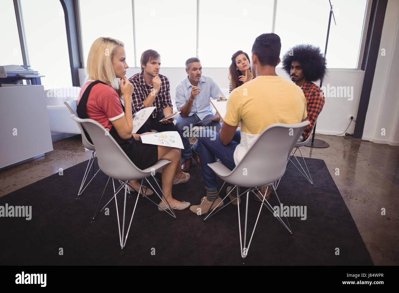 Grave la gente di affari piani disscussing mentre è seduto in ufficio creativo Foto Stock