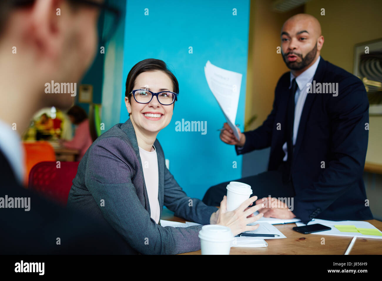 Ritratto di felice imprenditrice sorridente guardando il partner durante la riunione nella moderna agenzia creativa Foto Stock