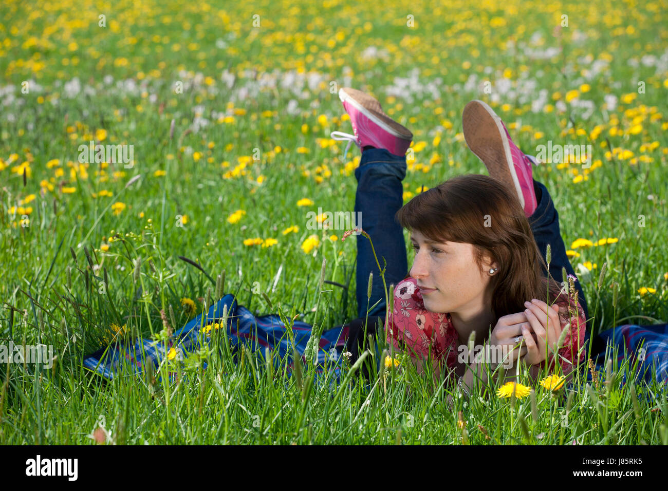 Giovane donna rilassarsi sul prato di primavera Foto Stock
