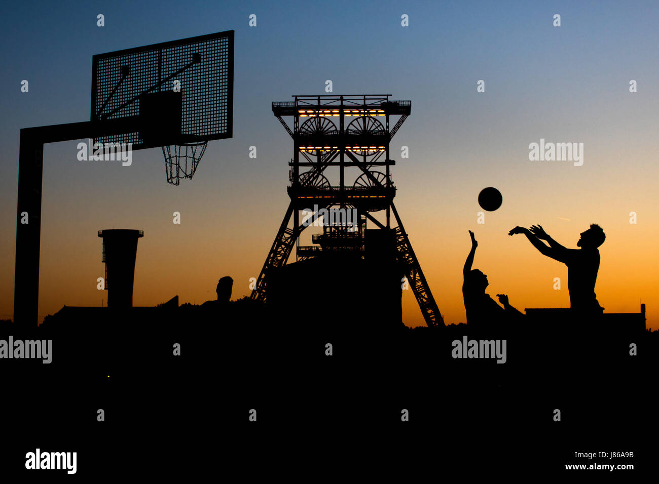 Gelsenkirchen (Germania). 26 Maggio, 2017. Gli uomini giocano a basket durante il tramonto su un campo di pallacanestro di fronte alla ex Zeche consolidamento a Gelsenkirchen, Germania, 26 maggio 2017. Foto: Marcel Kusch/dpa/Alamy Live News Foto Stock