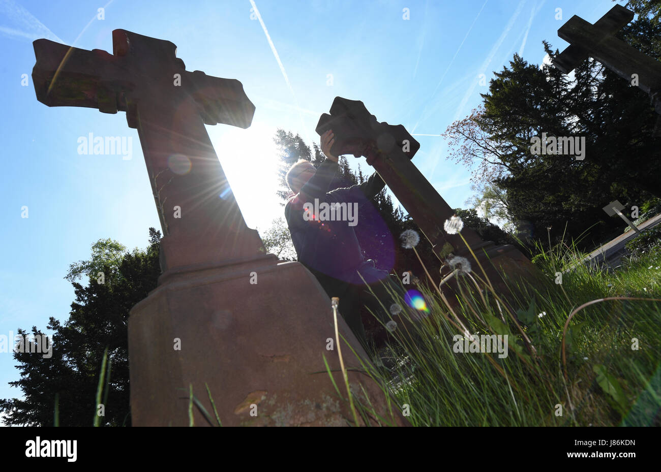 Il giardiniere Markus Preissler controlla croci sulle lapidi presso la principale cemeterey di Frankfurt am Main, Germania, 9 maggio 2017. Diverse migliaia di lapidi sono controllate ogni anno per mantenere la loro integrità ed evitare incidenti. Foto: Arne Dedert/dpa Foto Stock