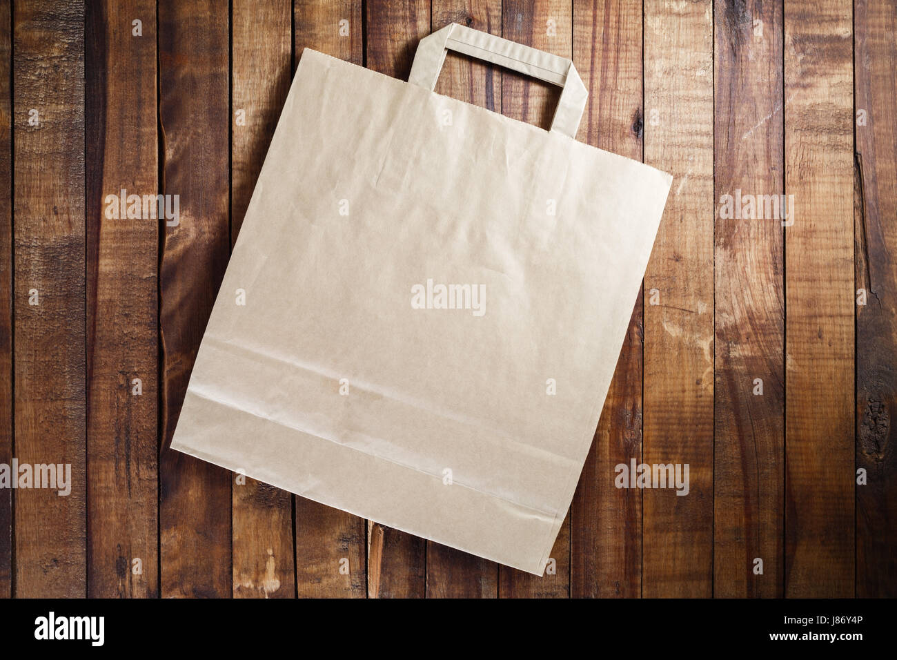 Riciclata carta craft shopping bag su vintage tavolo in legno sfondo. Vista dall'alto. Foto Stock