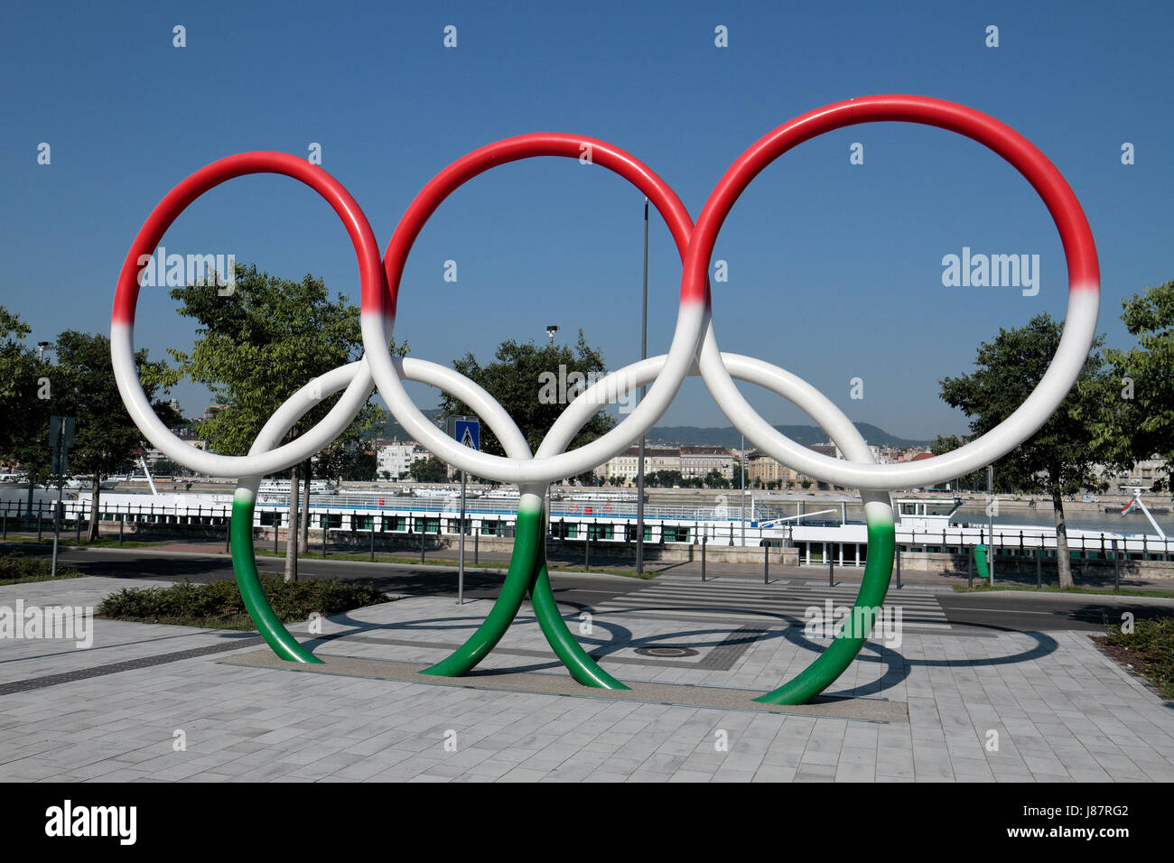 Gli anelli olimpici dipinto in la bandiera ungherese colori (Budapest offerta fro 2024 giochi) accanto al fiume Danubio a Budapest, Ungheria. Foto Stock