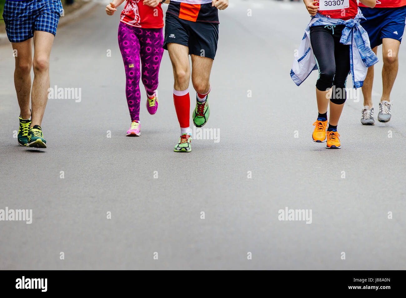 Gruppo di giovani corridori in esecuzione una strada di città in città mezza maratona Foto Stock