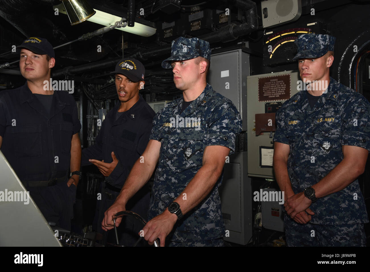 170523-N-HM829-183 OCEANO PACIFICO (maggio. 23, 2017) Guardiamarina di terza classe Seth Carithers dirige la nave mentre in piedi come timoniere sul ponte del Whidbey Island-class dock landing ship USS Rushmore (LSD 47). L'orientamento professionale e la formazione per aspiranti guardiamarina (CORTRAMID), per aspiranti guardiamarina classe terza e pacifico formazione degli aspiranti guardiamarina (PACTRAMID), per aspiranti guardiamarina secondo e di prima classe e serve come un opportunità per gli studenti universitari a sperimentare la vita in corso a bordo di una nave della marina americana con hands-on-the-acqua, sail training. (U.S. Navy foto di Sottufficiali di seconda classe K. Cecelia Engrums/Release Foto Stock