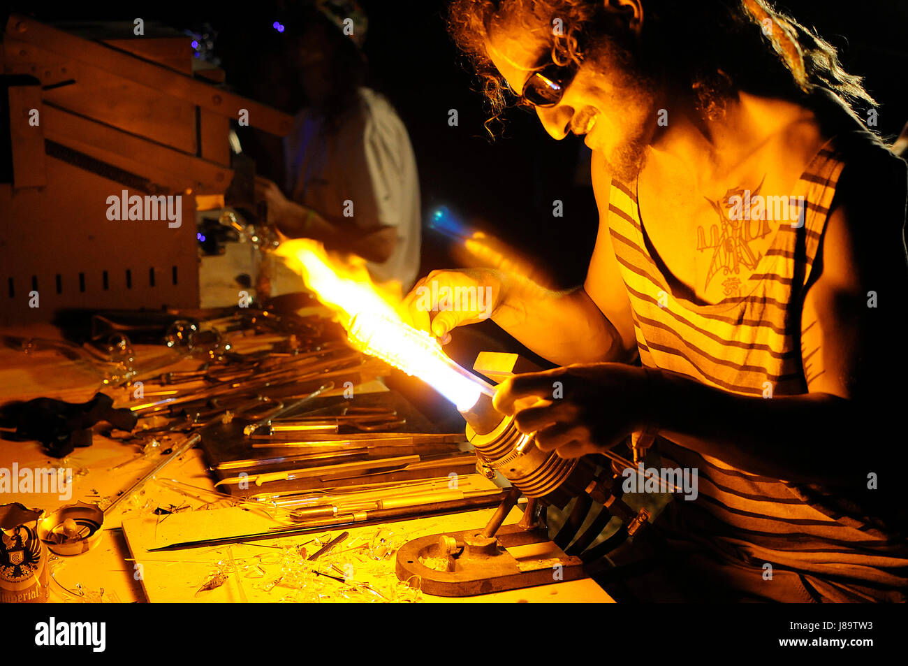 Un uomo soffia tubi di vetro durante il 2014 immaginano di Festival in Costa Rica. Foto Stock