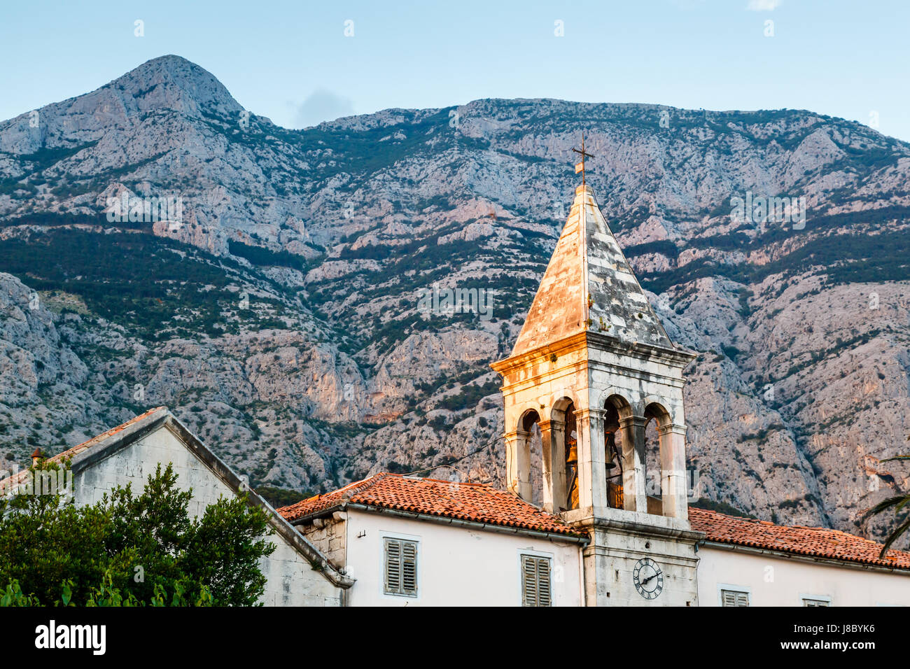 Campanile medievale e la montagna Biokovo in background, Makarska, Croazia Foto Stock