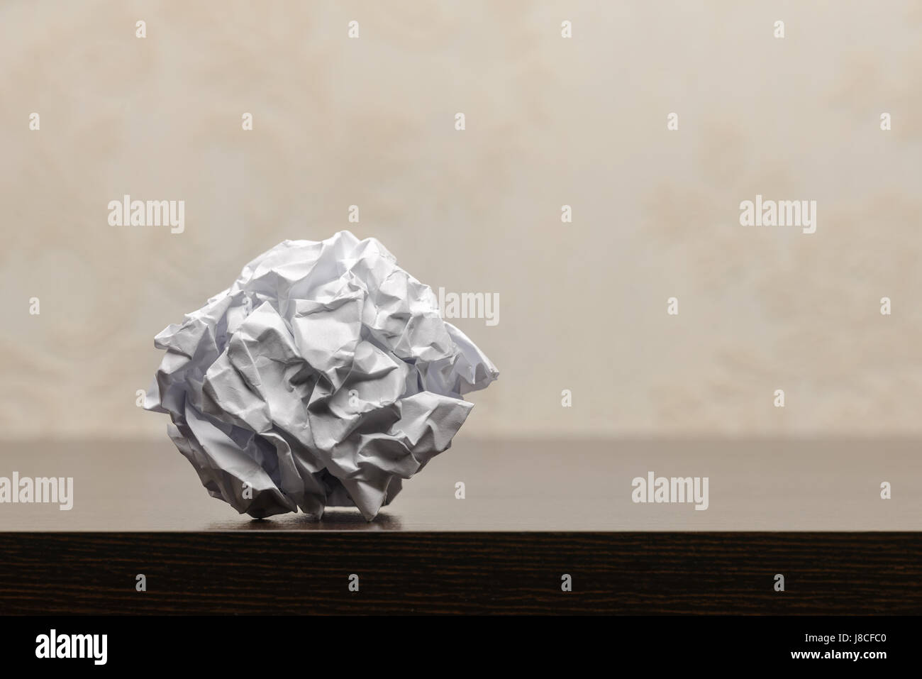 Carta sgualcita palla al buio su un tavolo di legno. Attività di ricerca o di processo creativo concept Foto Stock