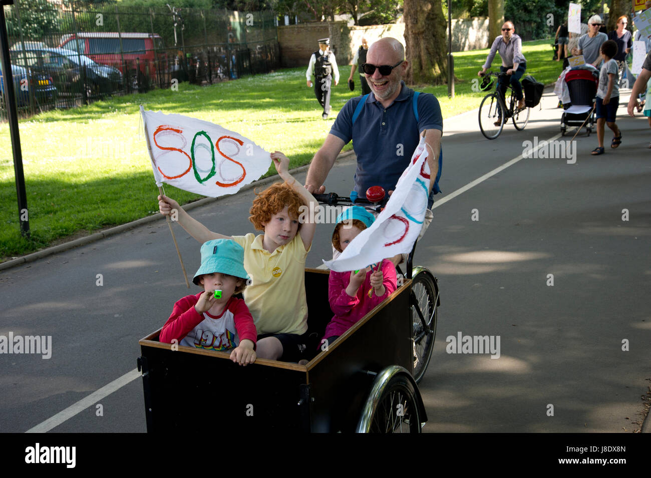 Protesta contro il governo prevede di tagliare più di 600 insegnanti a Hackney. Tre bambini sono trasportati in un rimorchio per biciclette. Foto Stock
