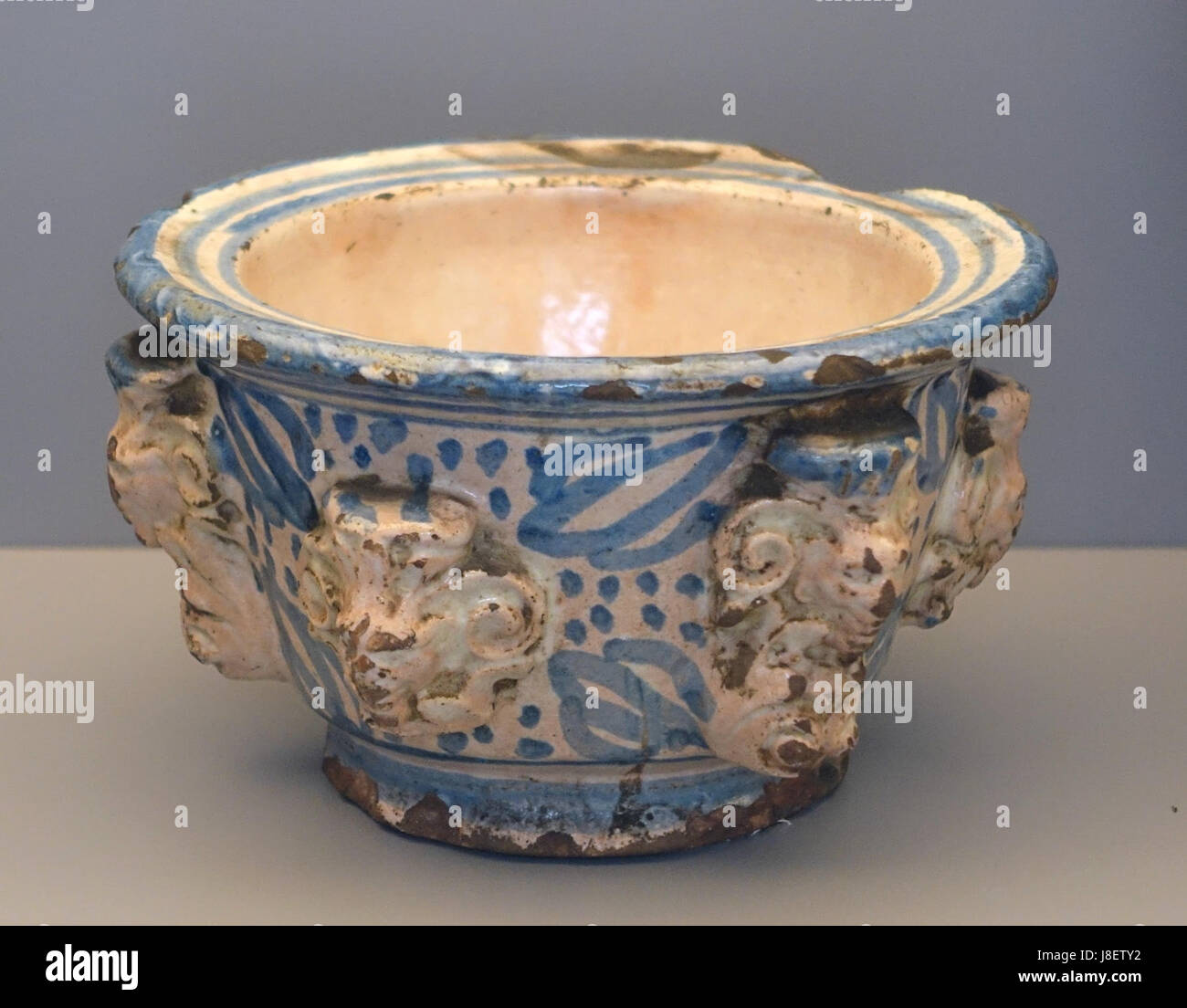 Un mortaio in ceramica del XVI secolo proveniente da Teruel, Spagna, con volti in rilievo, esposto al Museo Nacional de Artes Decorativas di Madrid, che mostra l'artigianato storico spagnolo. Foto Stock