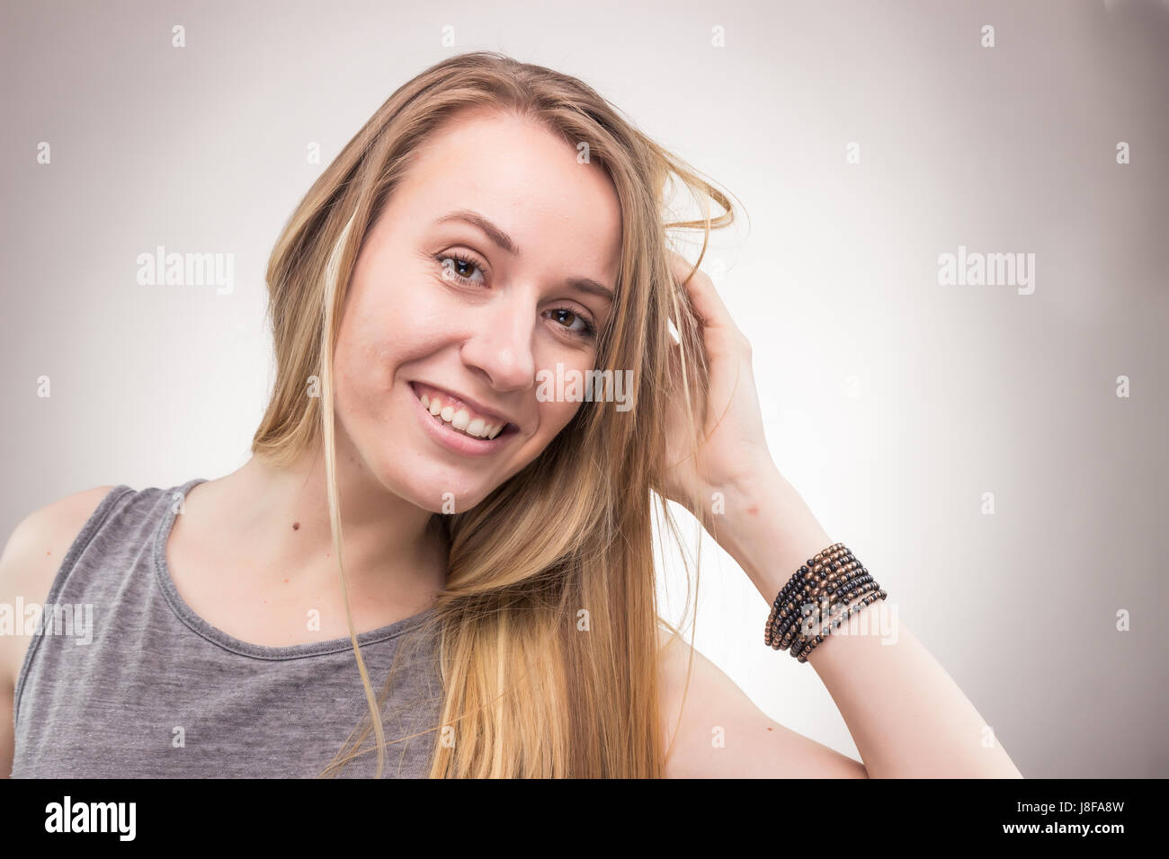 Ritratti, una giovane donna adulta, solo di sfondo per studio, abiti casual, faccia di testa headshot, Foto Stock