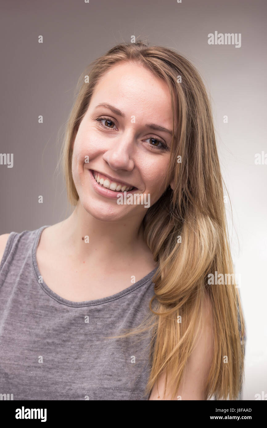 Ritratti, una giovane donna adulta, solo di sfondo per studio, abiti casual, faccia di testa headshot, Foto Stock