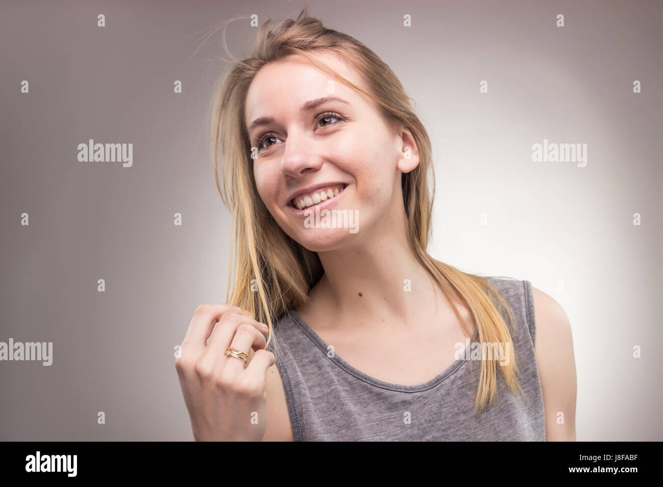 Ritratti, una giovane donna adulta, solo di sfondo per studio, abiti casual, faccia di testa headshot, Foto Stock