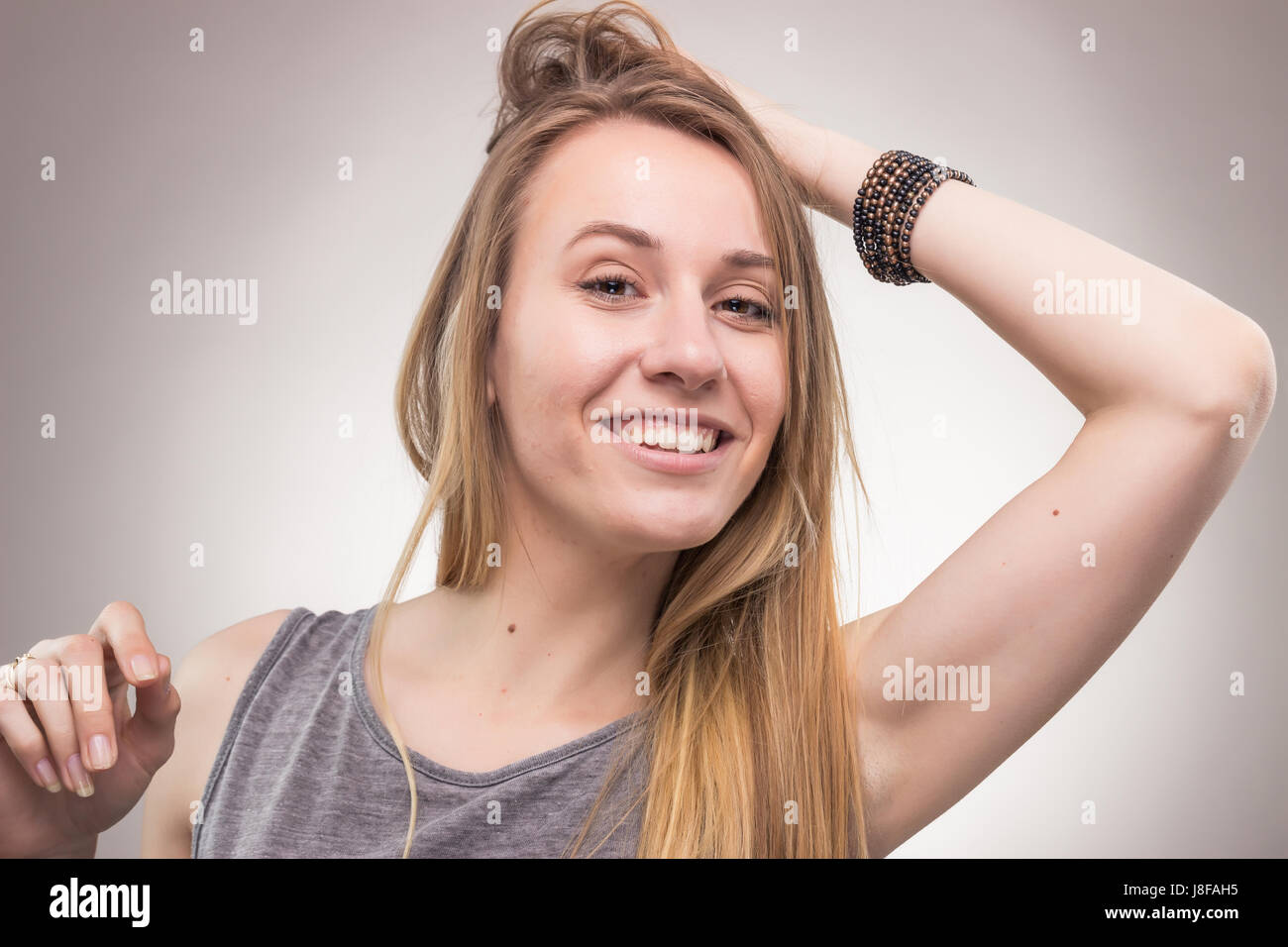 Una giovane donna adulta, ritratto faccia di testa headshot, Candida pongono, sfondo, studio Foto Stock