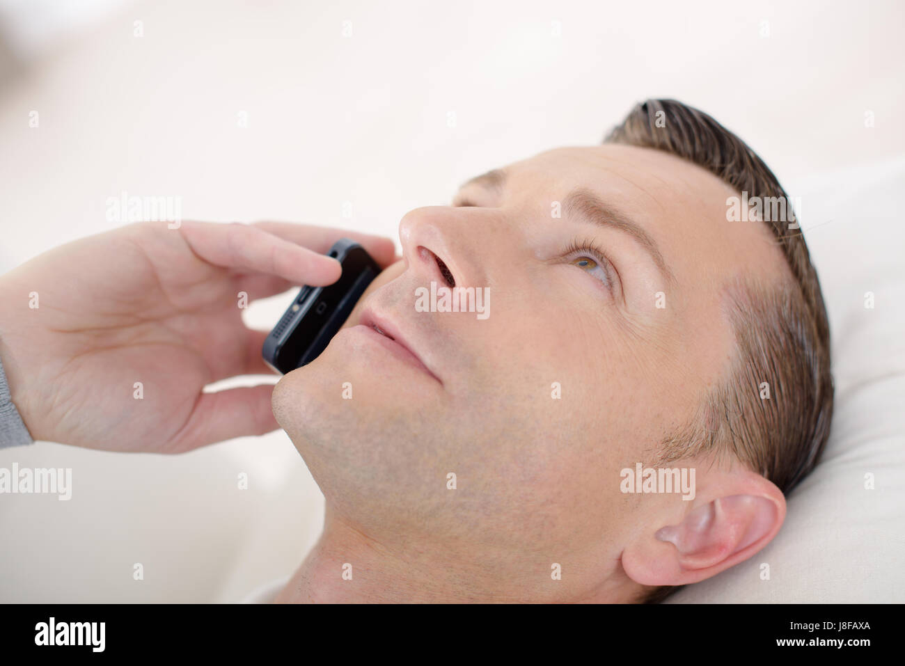 Uomo che parla sul suo telefono cellulare Foto Stock