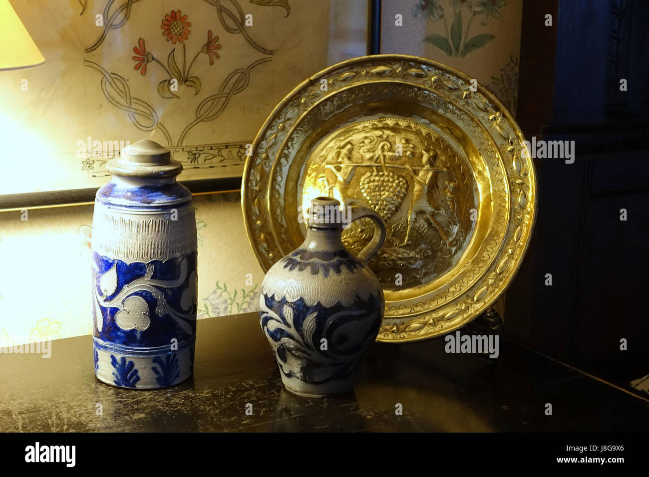 Le caraffe in ceramica con piatti in ottone, esposte a Kelmscott Manor nell'Oxfordshire, rappresentano le arti decorative e l'artigianato tipici dell'Inghilterra del XIX secolo. Foto Stock