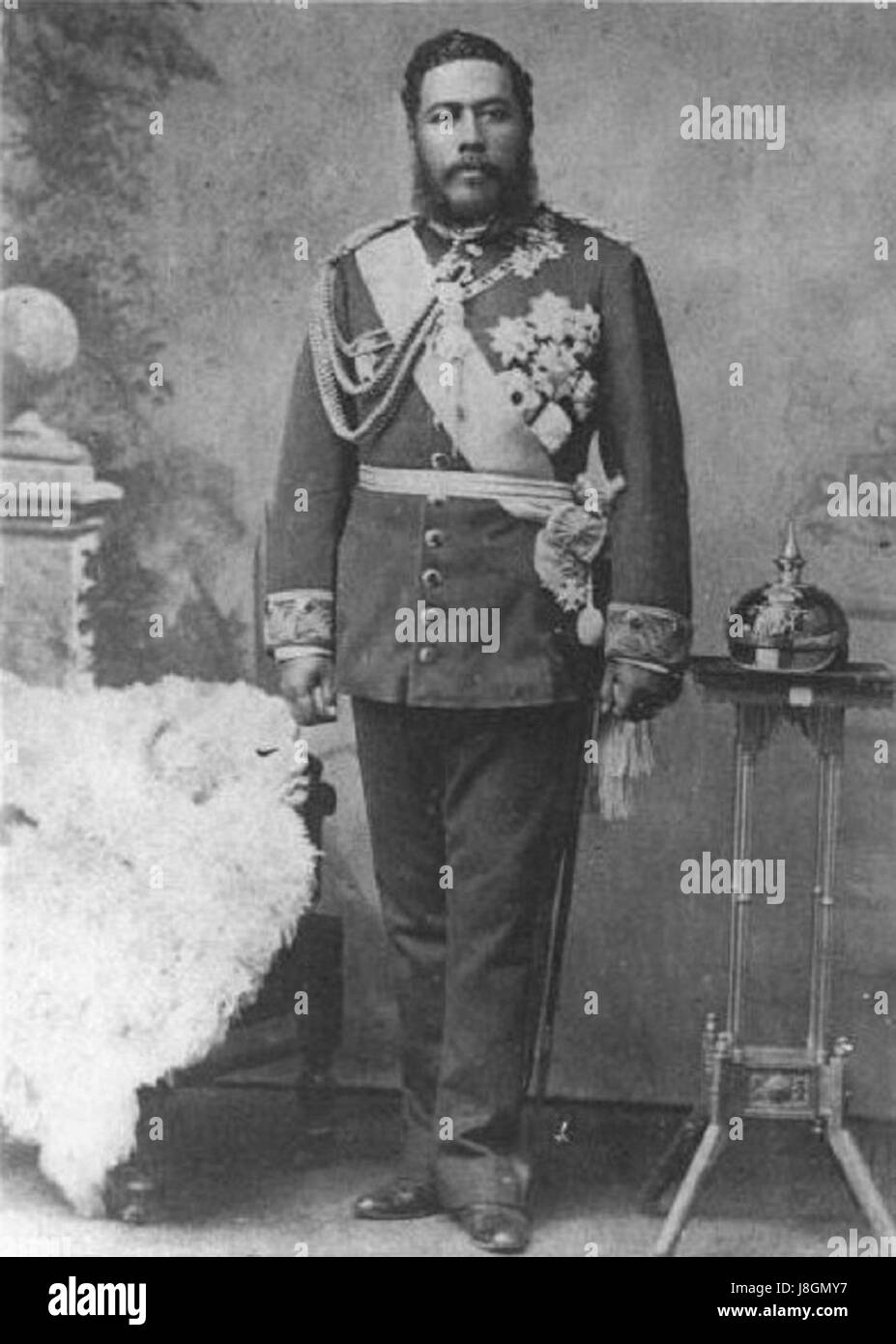 Kalakaua, il re delle Hawaii, è spesso associato al periodo storico della fine del XIX secolo, in particolare durante il suo regno. Il "Pickelhaube", un elmo a punta, fu utilizzato dalle forze militari tedesche, segnando un legame storico tra la famiglia reale hawaiana e il simbolismo militare europeo. Foto Stock