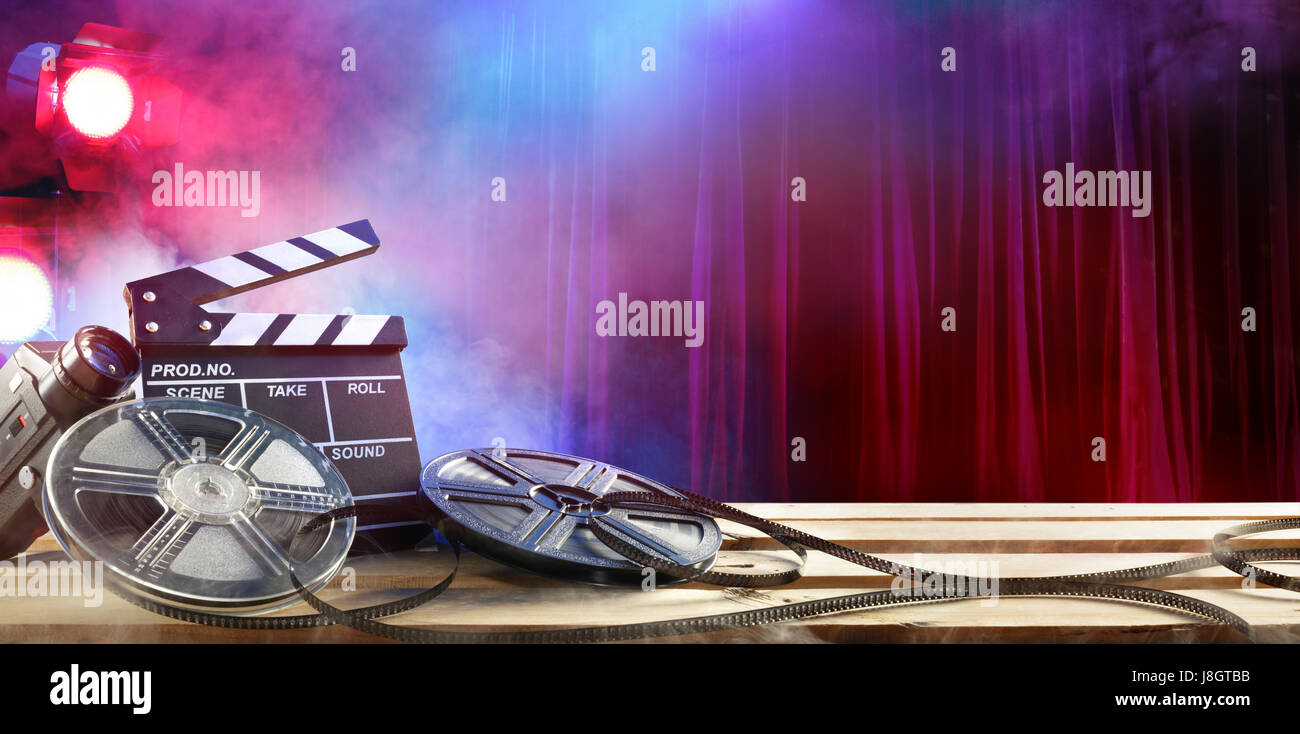 Film di sfondo - Clapperboard e bobine di pellicola in teatro Foto Stock