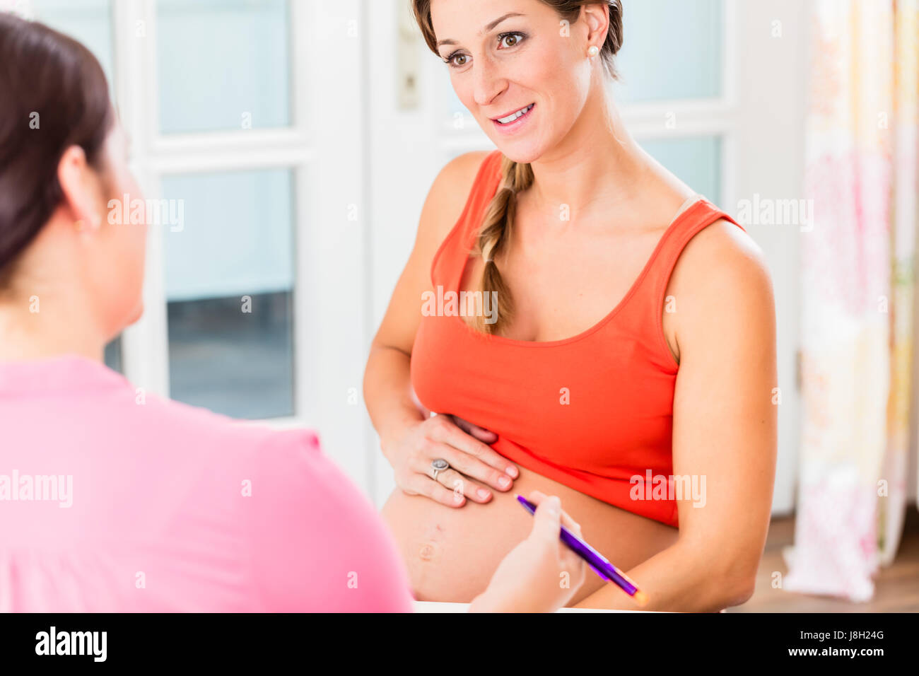 Madre in attesa con la mano sulla pancia incinta consulting midw Foto Stock