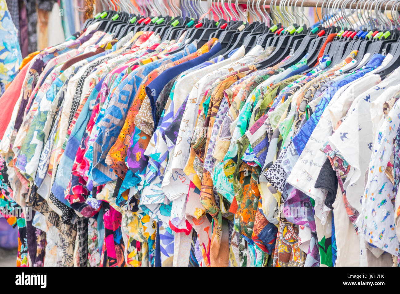 Shirt Varietà di colori dei vestiti appesi a cremagliera nella boutique. Foto Stock