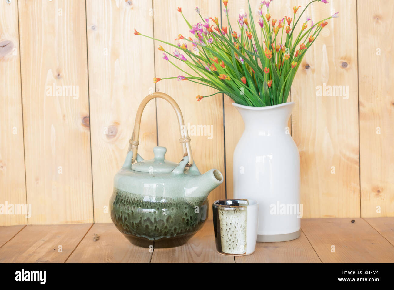 Teiera e vaso su un sfondo di legno. Foto Stock