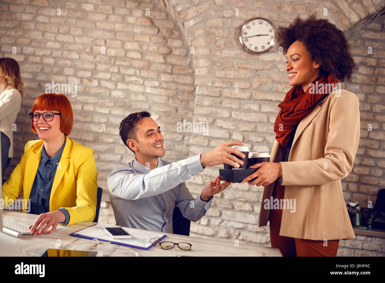 Carina ragazza afro-americana che serve caffè in design studio Foto Stock