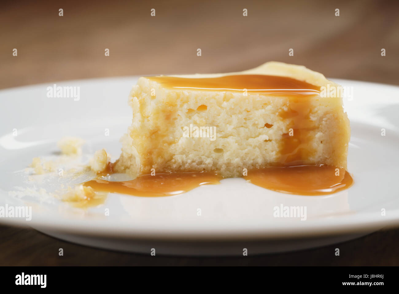 Cheesecake con salsa di caramello sulla piastra closeup mangiato Foto Stock