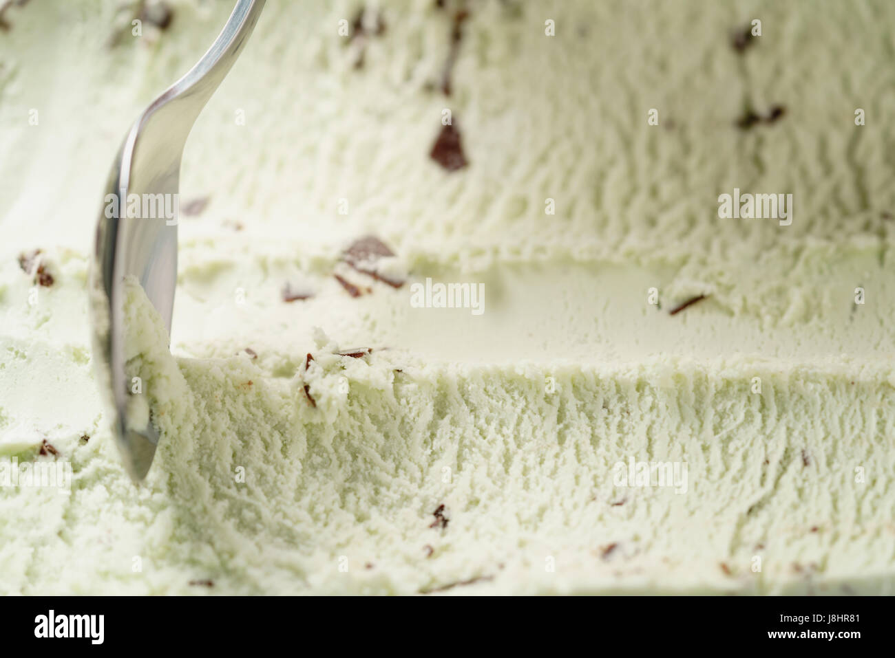 Mint gelato alla crema con scaglie di cioccolato scavato con cucchiaio Foto Stock