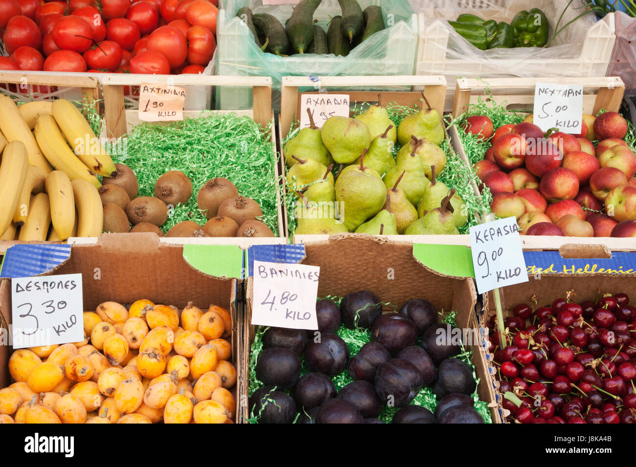 Stalla del mercato greco con frutta e verdura fresche, comprese prugne, ciliegie, banane, kiwi, pere, nettarine, pomodori, zucca e peperoni verdi Foto Stock