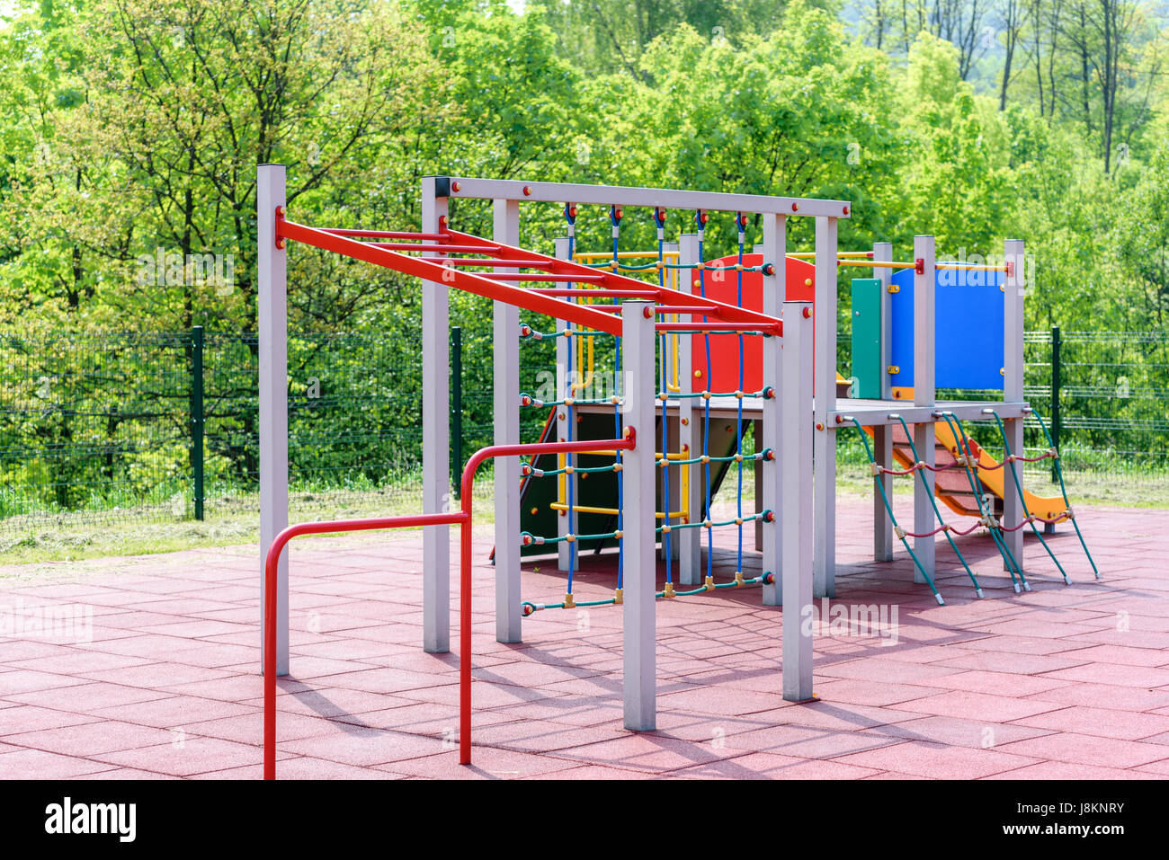 Parco giochi per bambini in un parco pubblico o al di fuori di un asilo nido sullo sfondo di verdi alberi Foto Stock