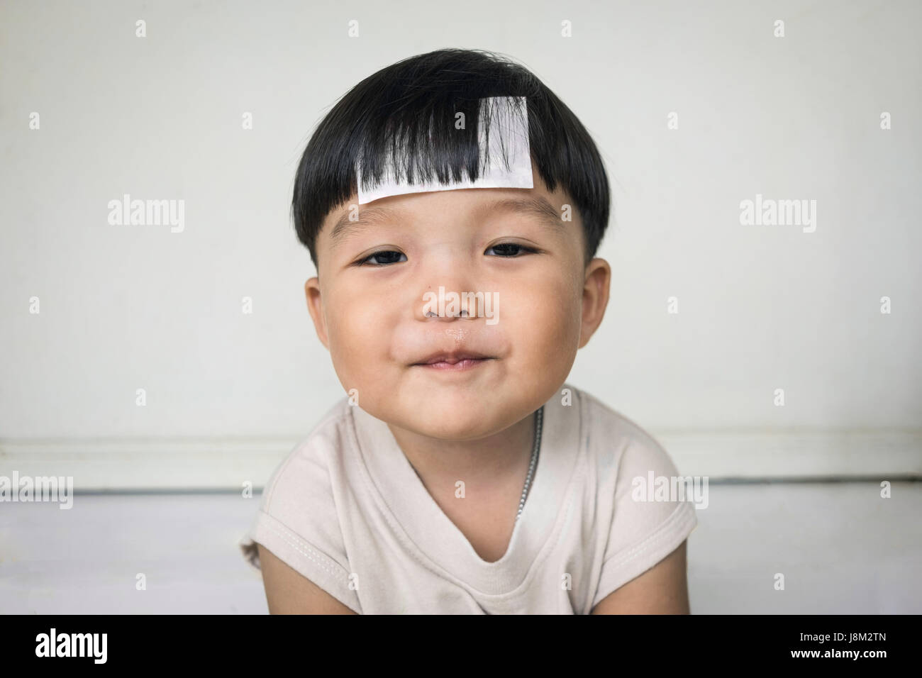 Adorabili e paffuto ragazzo sorridendo con chubby cheeked Foto Stock