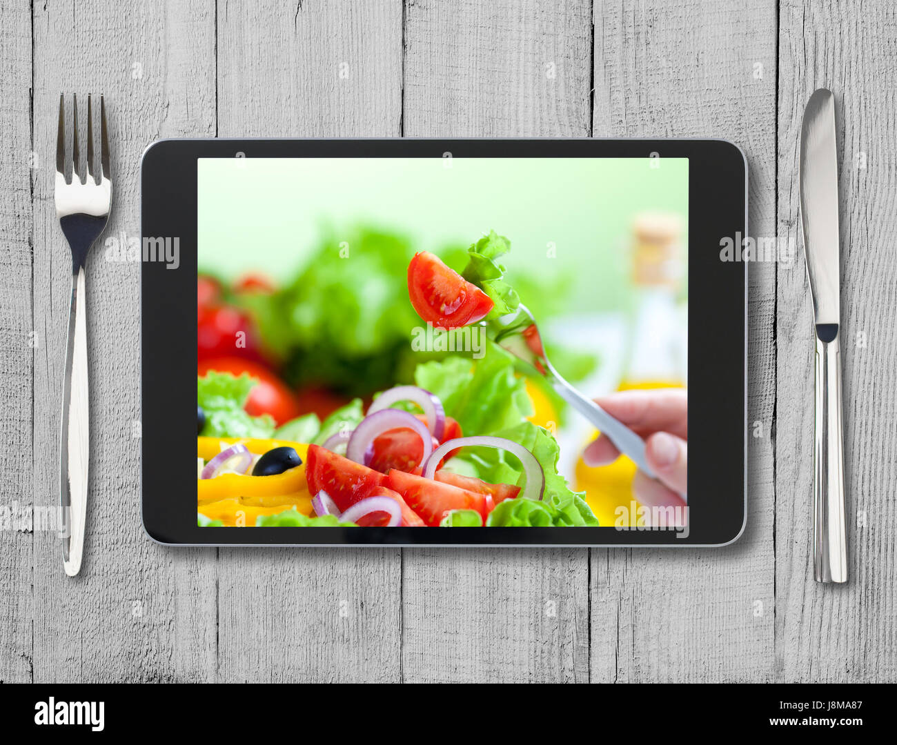 Nero tablet pc con cibo sano sullo schermo e tavolo in legno Foto Stock