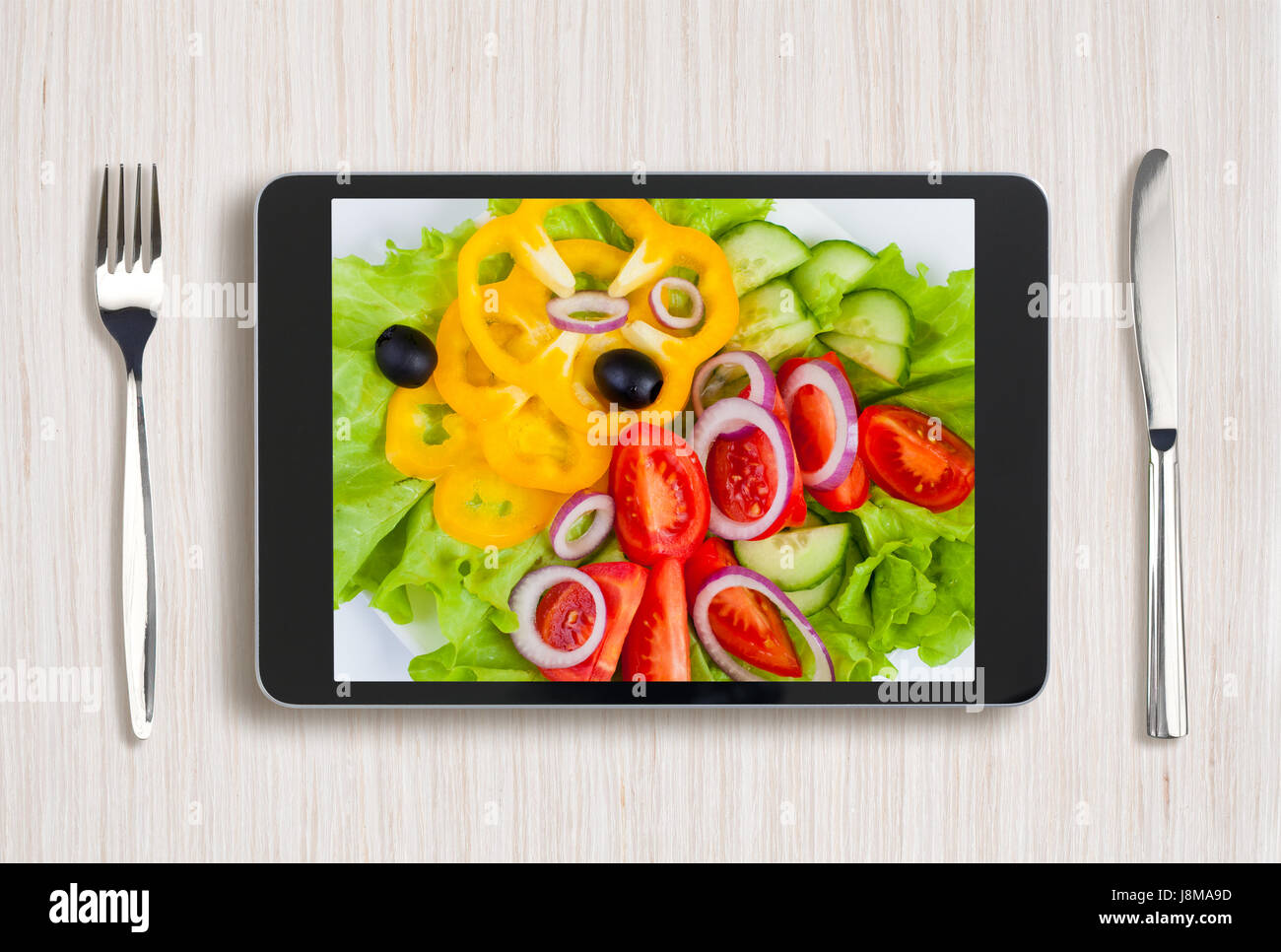 Nero tablet pc con cibo sano sullo schermo e tavolo in legno Foto Stock
