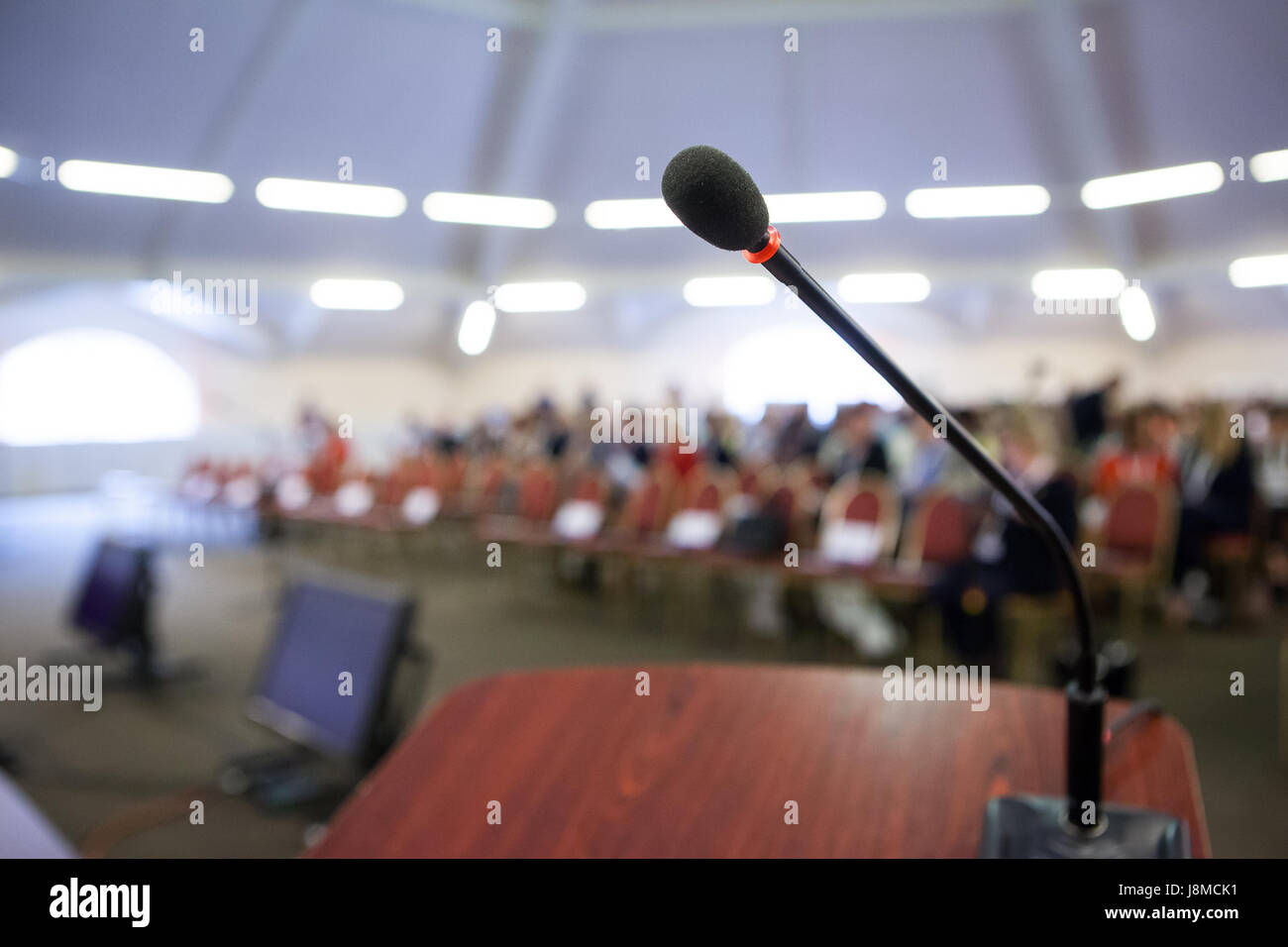 La parola o il concetto di conferenza. Microfono di stare davanti al pubblico. Foto Stock