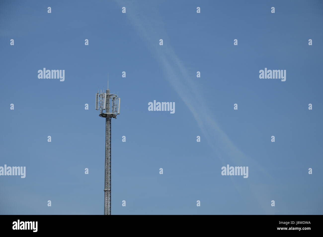 Cella di telecomunicazioni telefono torre con antenne contro un cielo blu sullo sfondo Foto Stock